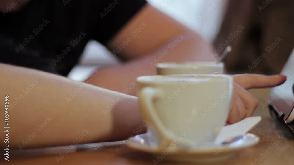 man and woman drinking coffee and working on the tablet man and woman drinking coffee and working on the tablet