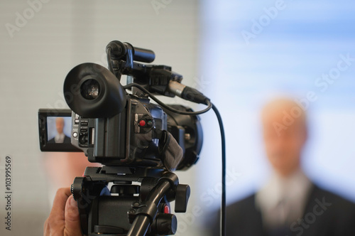 Public relations. Spokesman making a statement for camera. Camera in focus