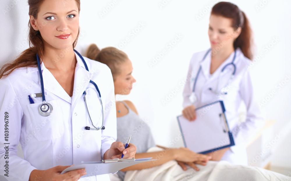 Smiling female doctor with a folder in uniform standing at hospital Smiling female doctor with a folder in uniform standing at hospital