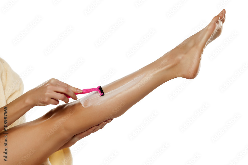 young woman shaving her legs with razor young woman shaving her legs with razor