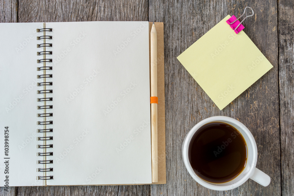 Open notebook on wooden background with coffee cup and yellow no Open notebook on wooden background with coffee cup and yellow no