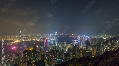 Wallpaper Mural Hong Kong city skyline timelapse at night with Victoria Harbor and skyscrapers illuminated by lights over water viewed from mountain top. Torontodigital.ca