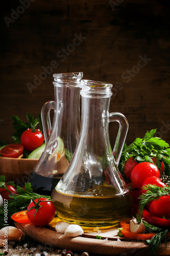 Fresh olive oil in glass carafe with tomatoes, peppers, cucumber