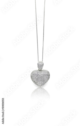 A beautiful heart shaped pave diamond and white gold or silver pendant dangles from a chain. Fine Jewelry necklace isolated on a white background with shadow and reflection