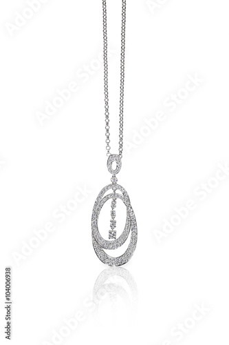 A beautiful diamond and gold pendant dangles from a chain. Fine Jewelry necklace isolated on a white background with shadow and reflection