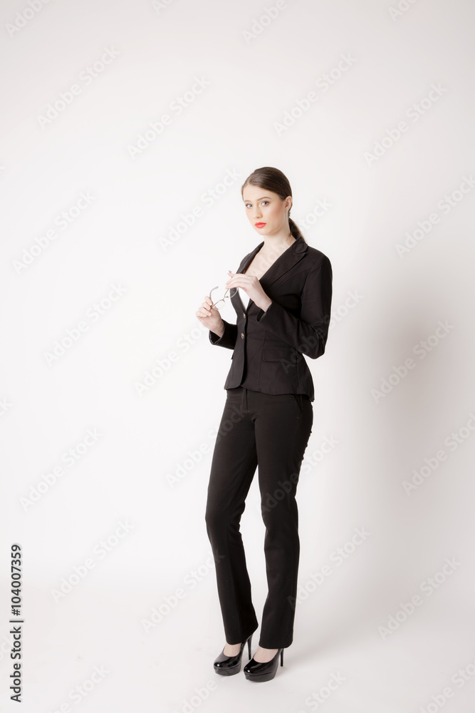 Portrait of business woman with glasses on a white background. Business girl in suit on the background wall. Portrait of business woman with glasses on a white background. Business girl in suit on the background wall.