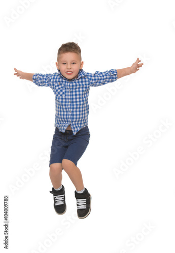 Little boy in shirt and shorts jumps spread wide his arms - Isolated on white background