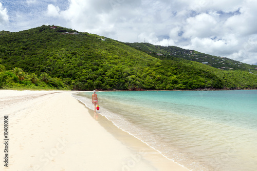 young woman walking on the shore of a tropical beach in the Cari photo