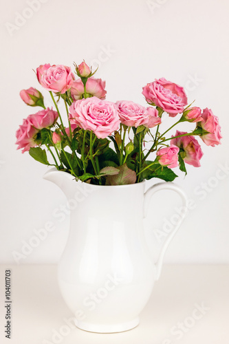 Pink flowers in white jug. Roses in jug. © perekotypole