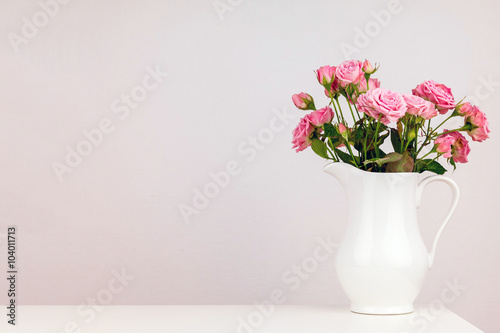 Pink flowers in white jug. Roses in jug. © perekotypole