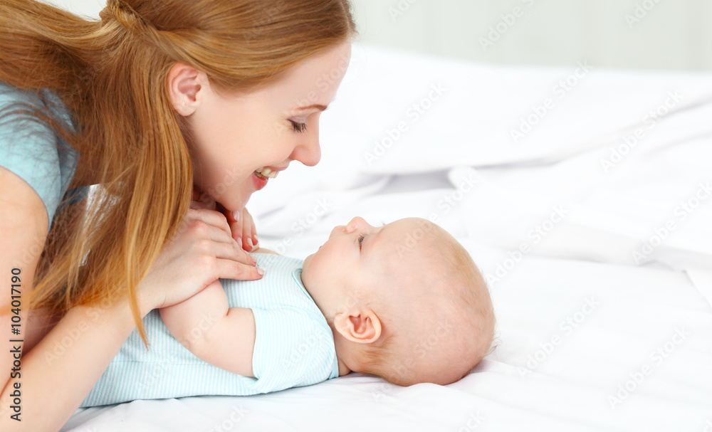 happy family mother playing with baby in bed happy family mother playing with baby in bed