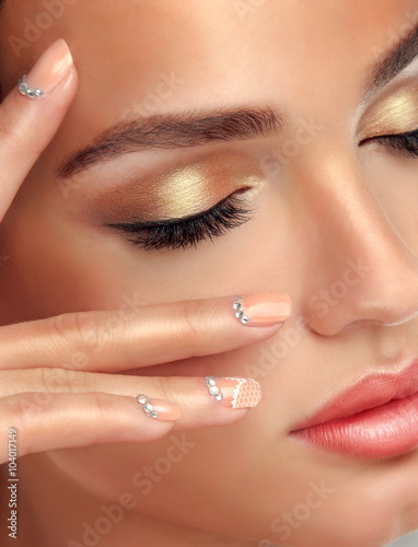 Luxury fashion style, manicure nail , cosmetics and makeup . beige nails with rhinestones  . Golden make up and eyelashes