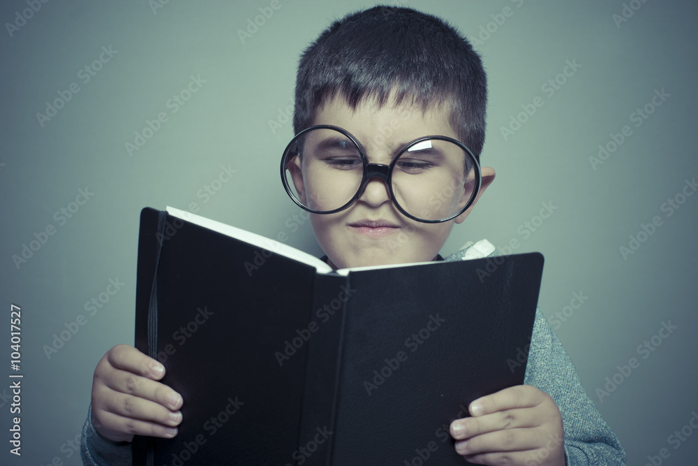 preschooler, dark-haired young student reading a funny book, rea