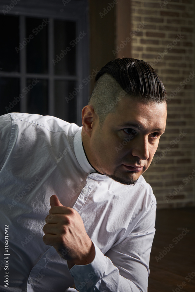 Portrait of young man, black slacks and white shirt, hairstyle with shaved  temples and slicked back hair at the head, emotions, black window, Brick  wall, beard, skinhead, brutal, evil, killer Stock Photo |
