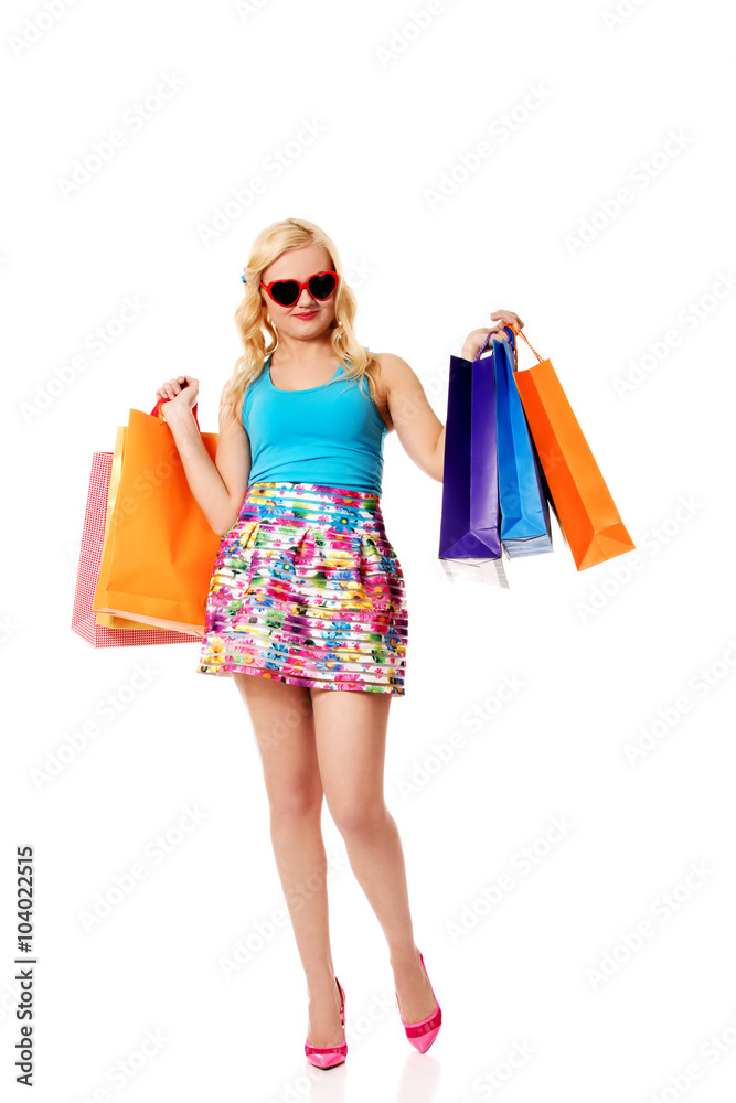 Happy woman in sunglasses holding shopping bags