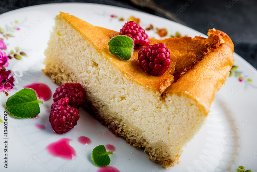 Cheesecake slice with raspberries and mint leaves on plate. Cheesecake slice with raspberries and mint leaves on plate.