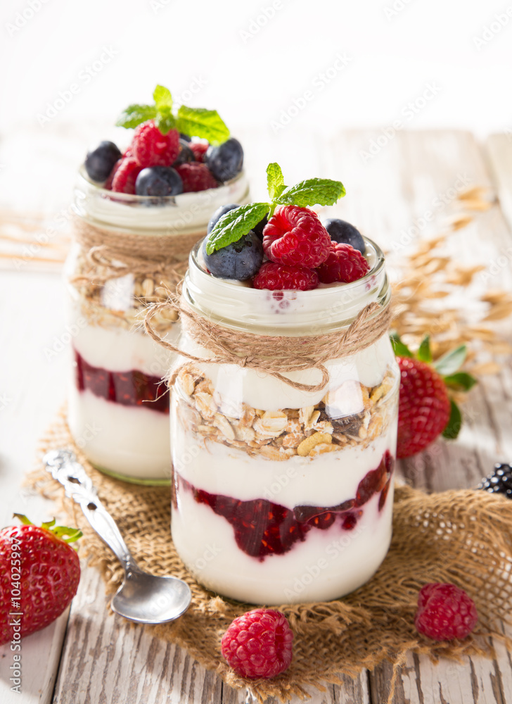 Tasty yoghurts with muesli, fresh berries and jam. Tasty yoghurts with muesli, fresh berries and jam.