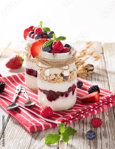 Tasty yoghurts with muesli, fresh berries and jam.