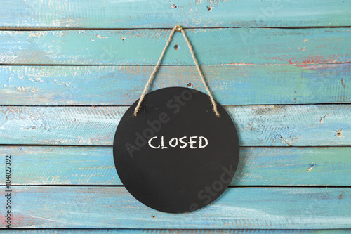 closed sign hanging on blue background