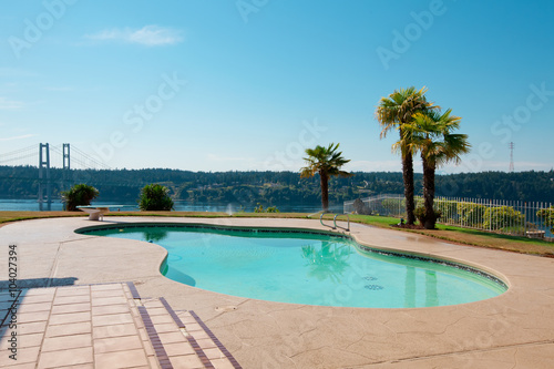 Pool to luxury waterfront house with palm trees and a view of Na © Iriana Shiyan