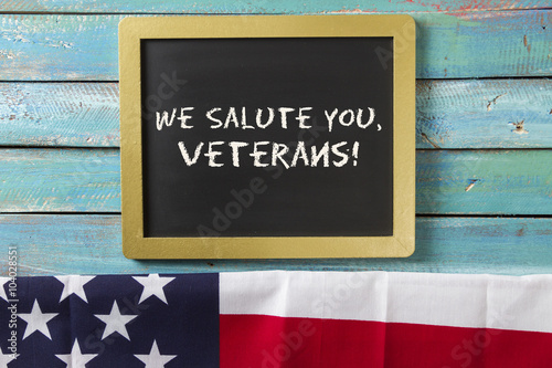veterans day chalk sign on blue wood background with flag