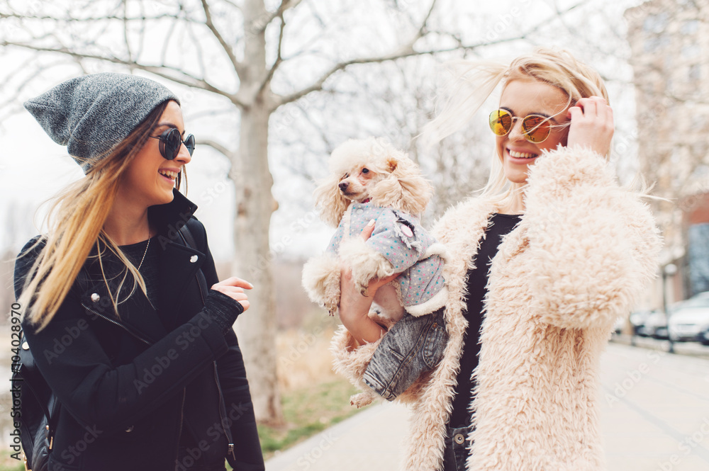 two young caucasian cute girls portrait with dog outdoor in park walking happy and smile all the way
two young caucasian cute girls portrait with dog outdoor in park walking happy and smile all the way