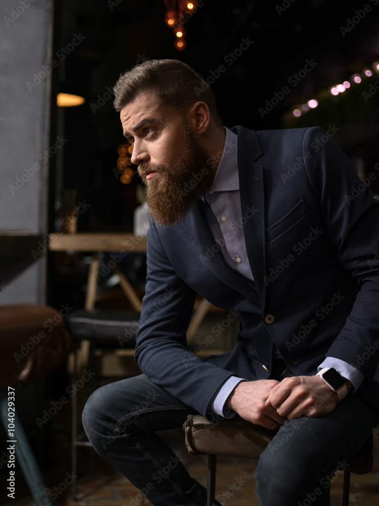 Cheerful bearded businessman is waiting in cafe Cheerful bearded businessman is waiting in cafe