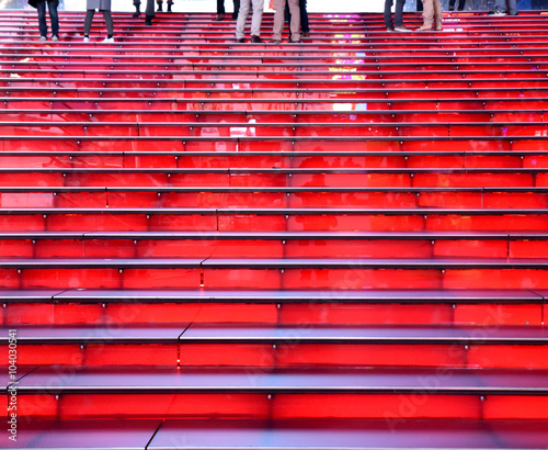 red grandstand steps in a row with feet at top