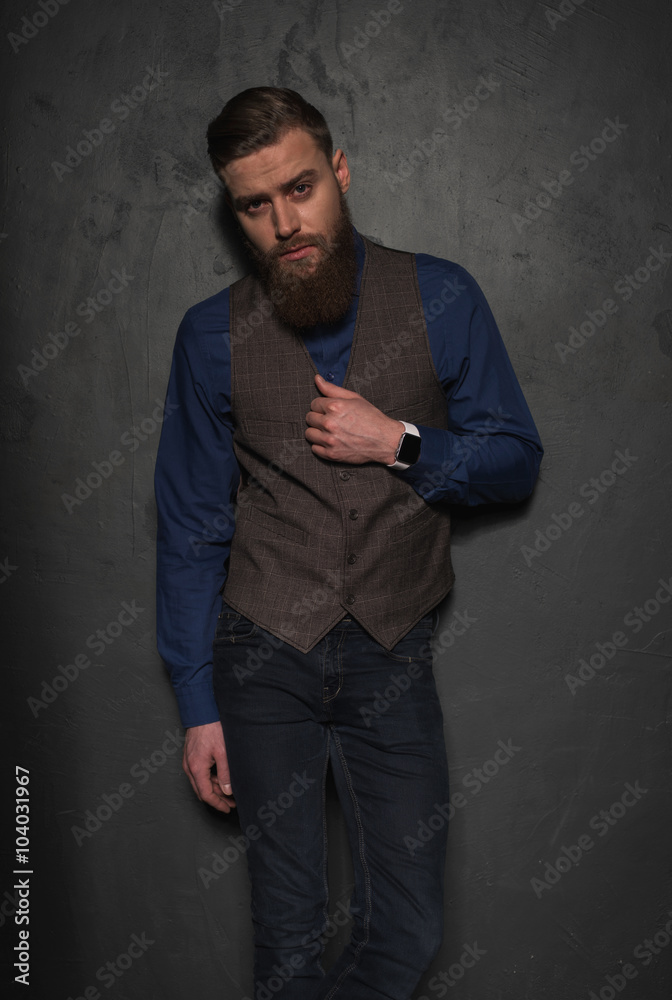 Cheerful young bearded businessman near the wall Cheerful young bearded businessman near the wall