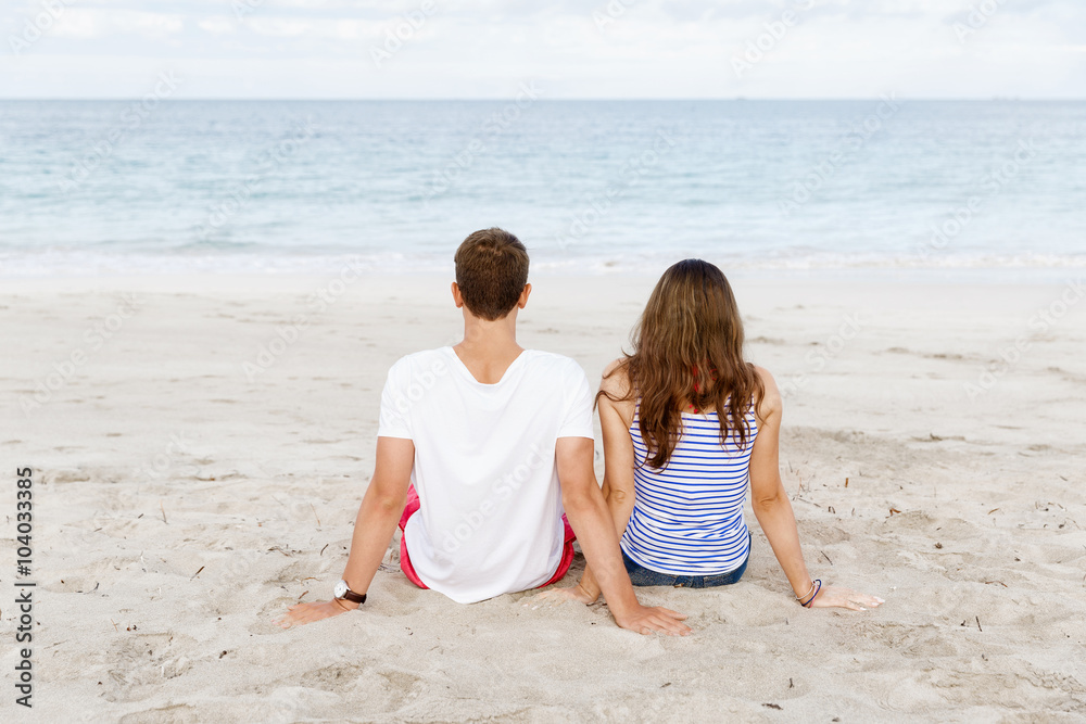Romantic young couple sitting on the beach Romantic young couple sitting on the beach