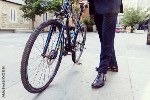 Successful businessman riding bicycle