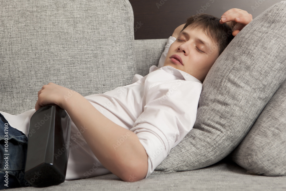 A man with a drinking problem is relaxing on a sofa A man with a drinking problem is relaxing on a sofa