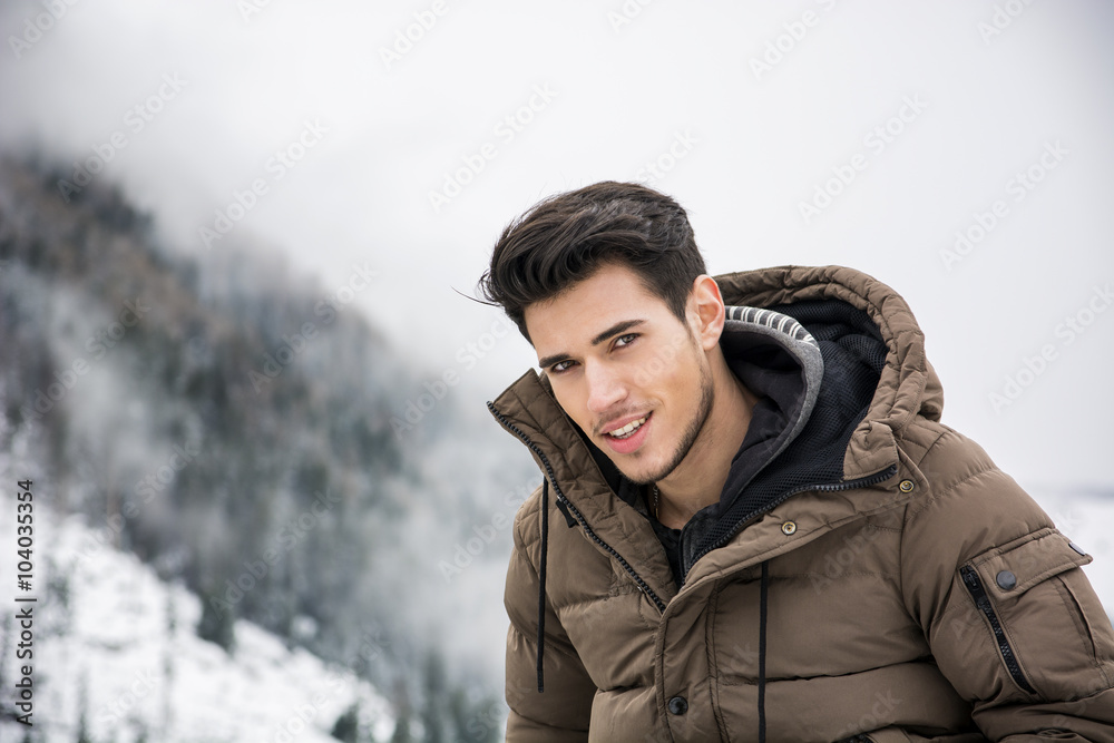 Man in outerwear sitting while looking at camera Man in outerwear sitting while looking at camera