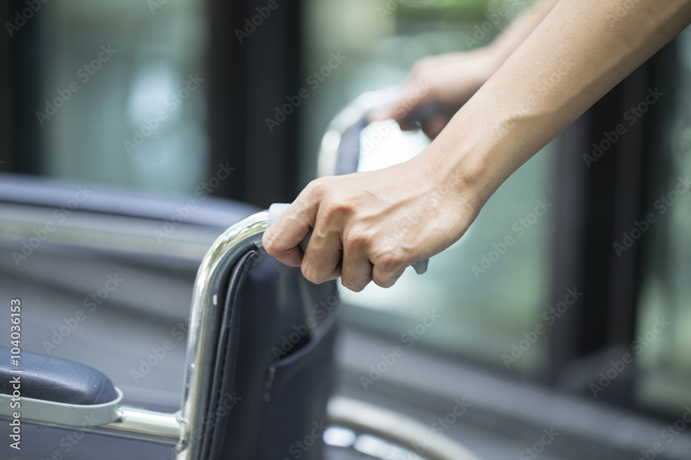 Empty wheelchair pushed by nurse's hands Empty wheelchair pushed by nurse's hands