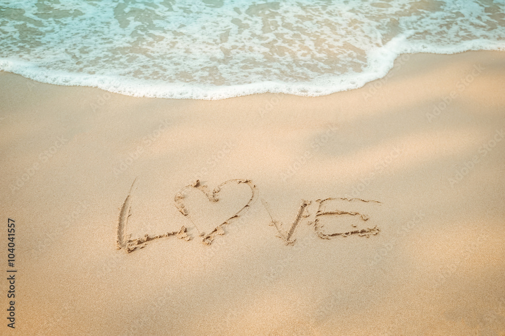 Fototapeta premium Love message hand writing on the sand beach