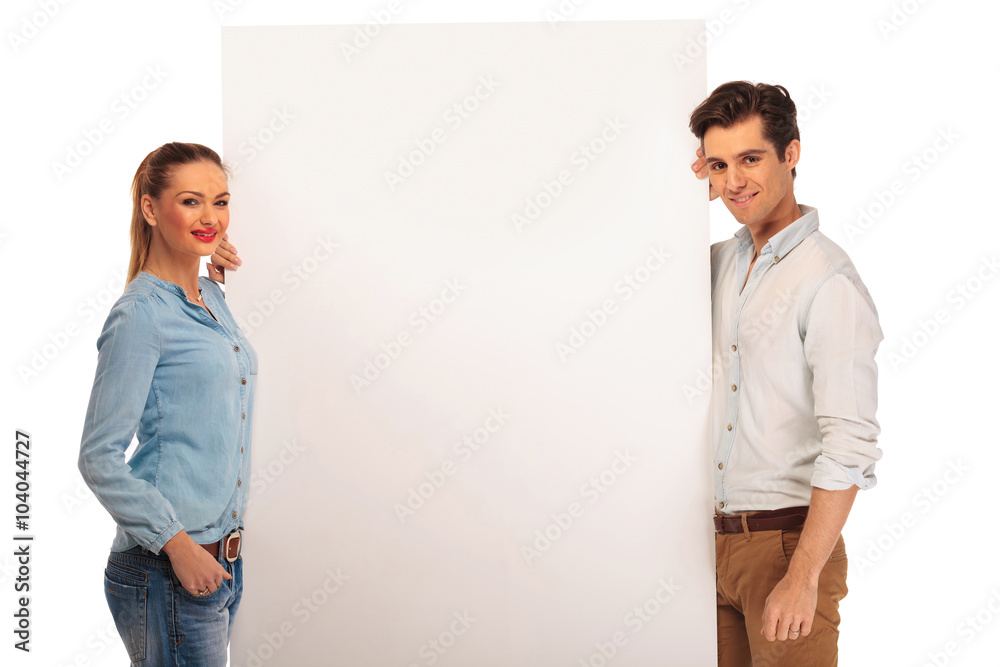 couple posing holding a white billboard couple posing holding a white billboard