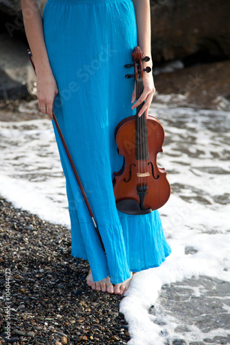 девушка в синем платье на берегу со скрипкой