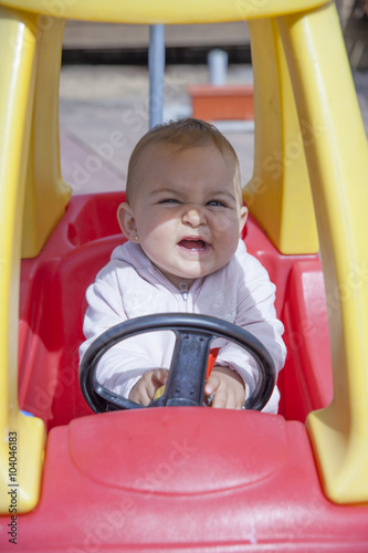 Close-up of funny little girl driving toy car © erllre