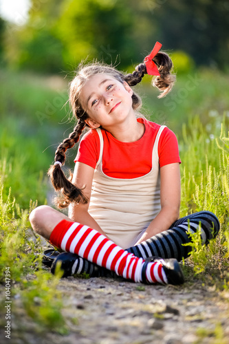 girl with pigtails imagines the summer on the nature photo