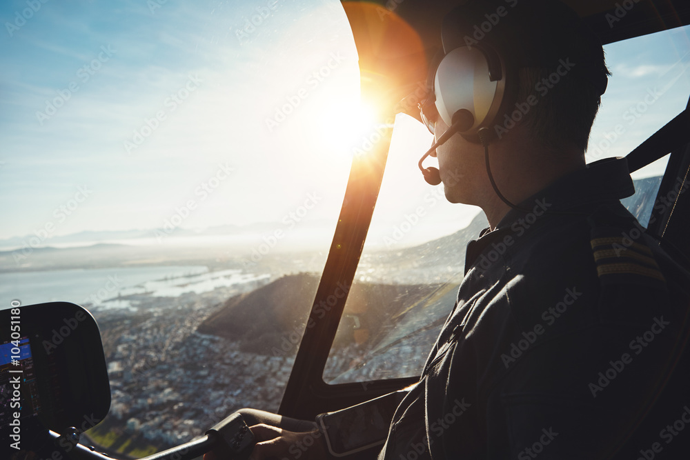 Helicopter pilot flying aircraft over a city - obrazy, fototapety, plakaty 