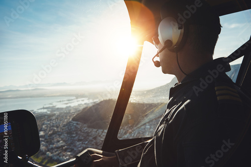Vászonkép Helicopter pilot flying aircraft over a city