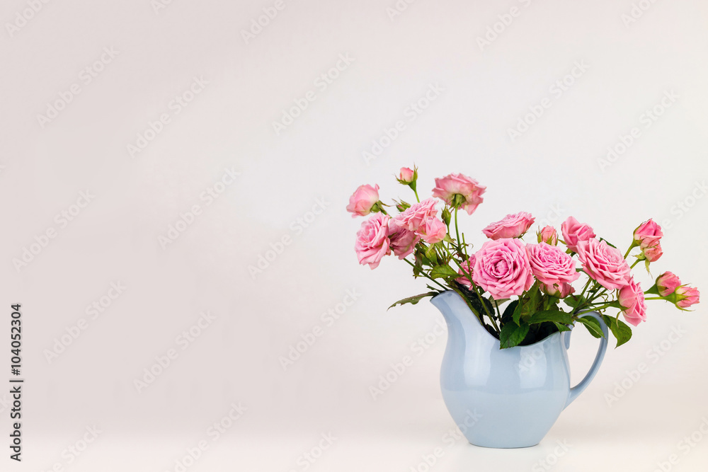 Pink flowers in blue jug. Roses in jug. Pink flowers in blue jug. Roses in jug.