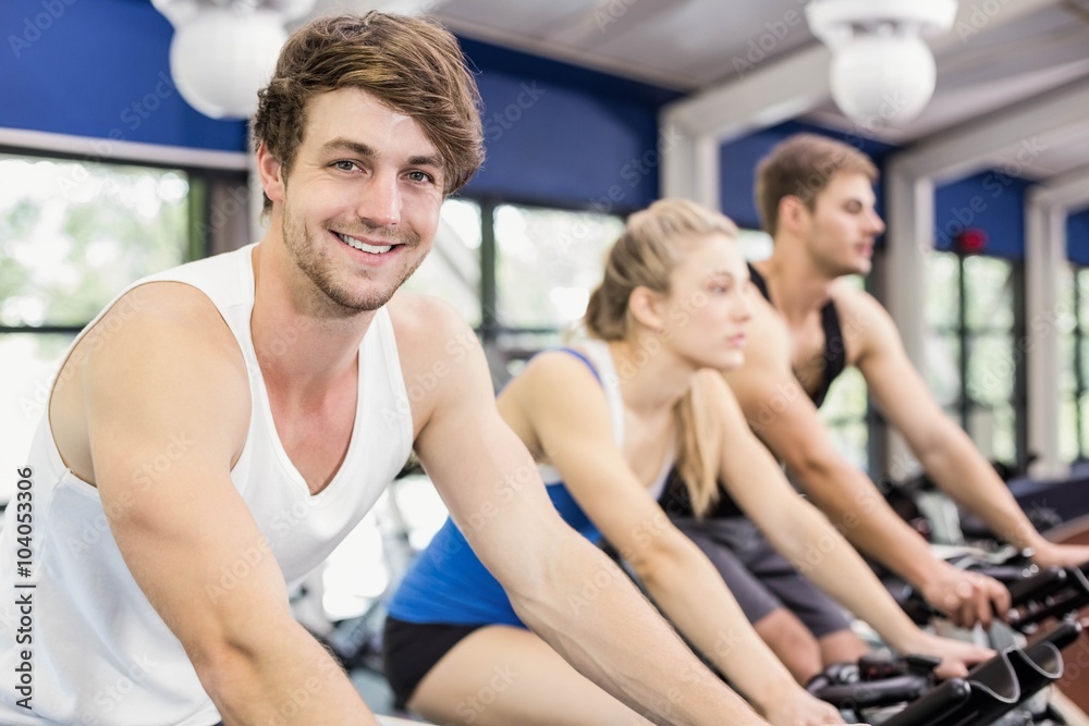 Fit group of people using exercise bike together Fit group of people using exercise bike together