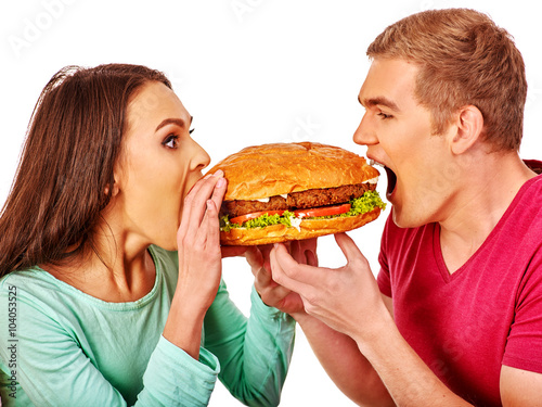 Man and woman biting big hamburgers . Fast food concept. Isolated.
