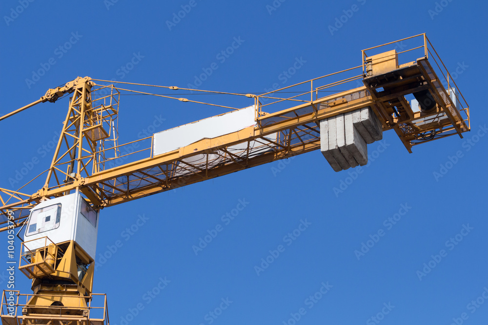 Construction crane on a blue sky background. Construction crane on a blue sky background.