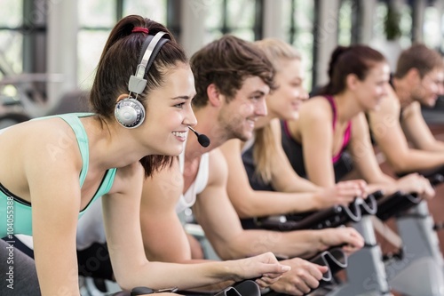 Fit group of people using exercise bike together