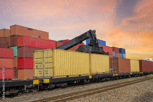 forklift handling and train  with container in shipyard for Logistic Import Export background  at sunset