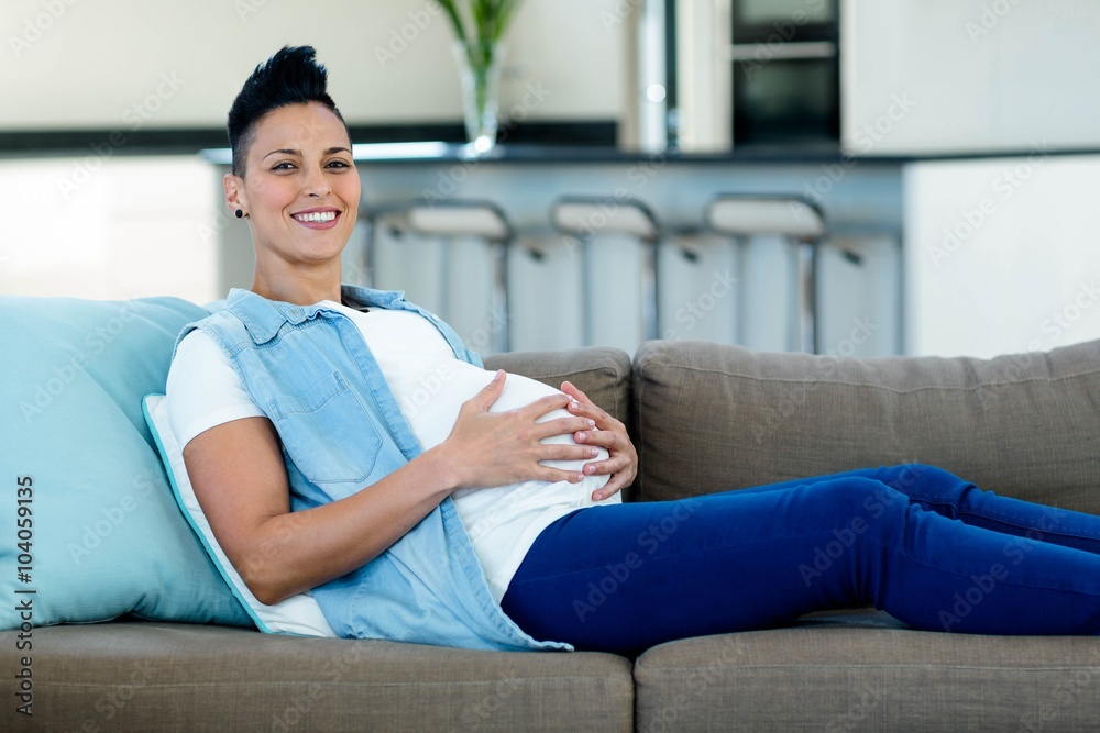 Portrait of pregnant woman relaxing on sofa