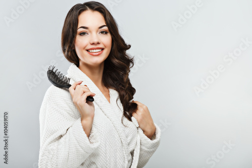 Young girl wearing bath robe holding a hair brush