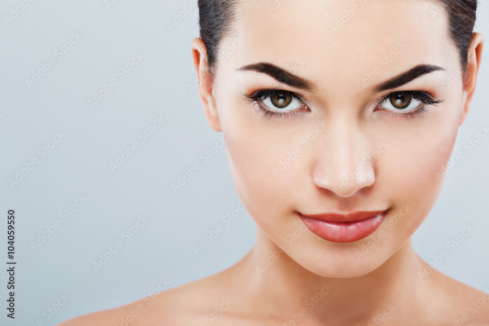 Fototapeta premium Lovely girl with dark hair at gray studio background